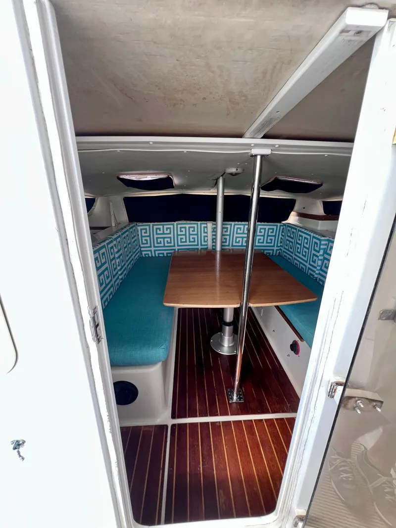 Slide: The Image of Interior of 1994 PDQ 32 Classic boat with wooden table and blue seating. - 27
