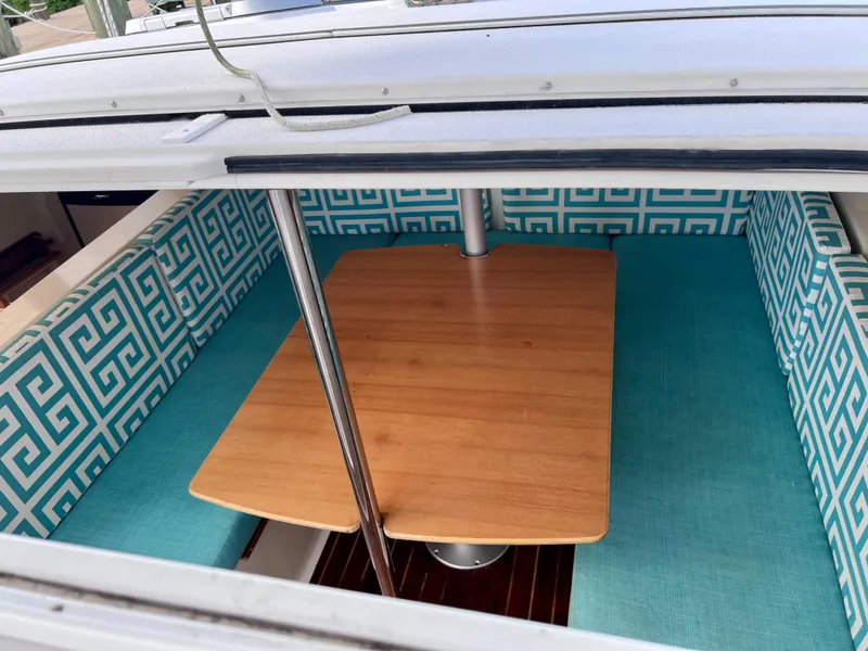 Slide: The Image of Interior of 1994 PDQ 32 Classic boat with turquoise patterned seating and wooden table. - 29