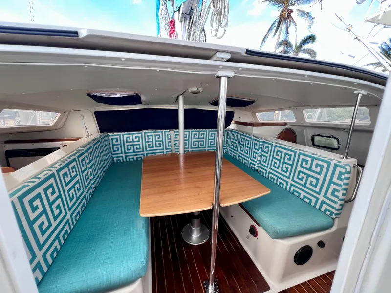 Slide: The Image of Interior of 1994 PDQ 32 Classic boat with patterned seating and wooden table. - 30