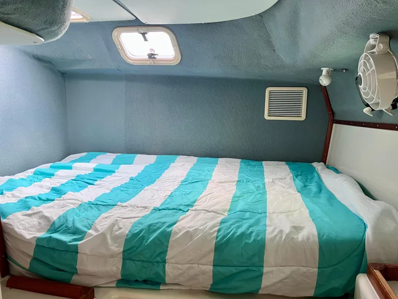 Slide: The Image of Interior cabin of 1994 PDQ 32 Classic with striped bedding and porthole window. - 38