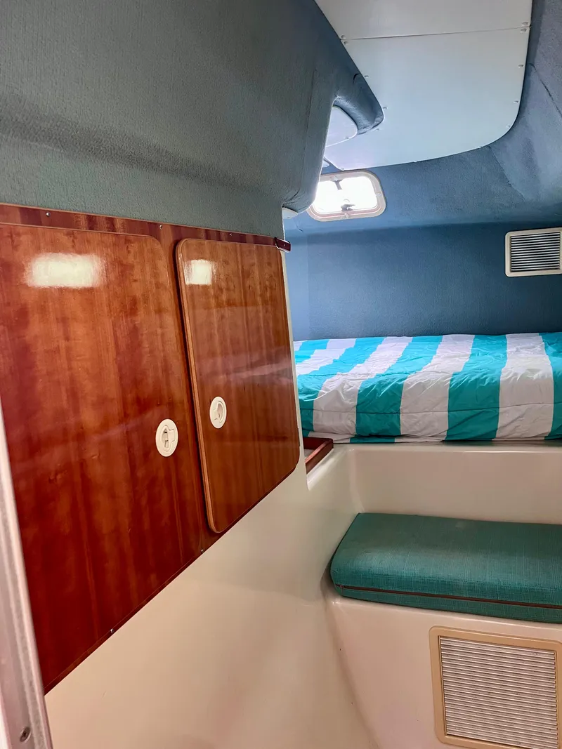 Slide: The Image of Interior cabin of 1994 PDQ 32 Classic boat with striped bedding and wooden cabinets. - 39