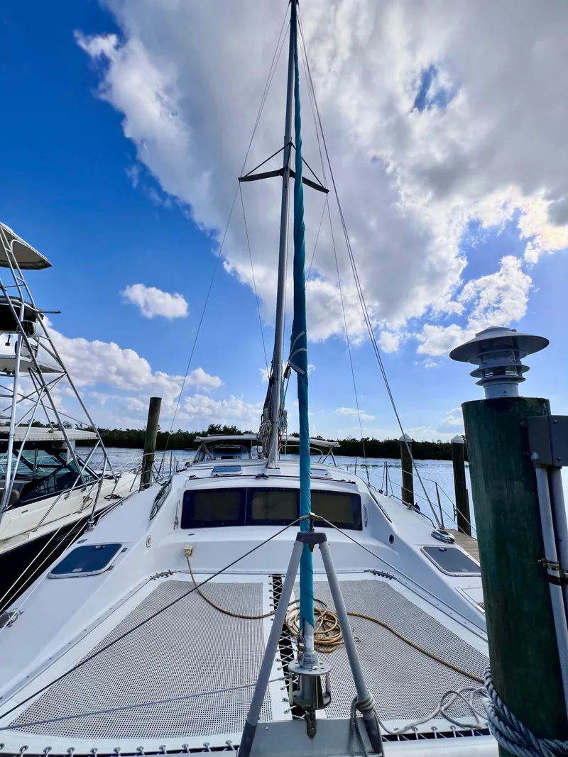 Slide: The Image of PDQ 32 Classic 1994 sailboat docked under a blue sky with clouds. - 4