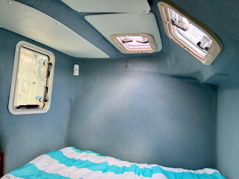 Slide: The Image of Interior cabin of 1994 PDQ 32 Classic boat with windows and striped bedding. - 40