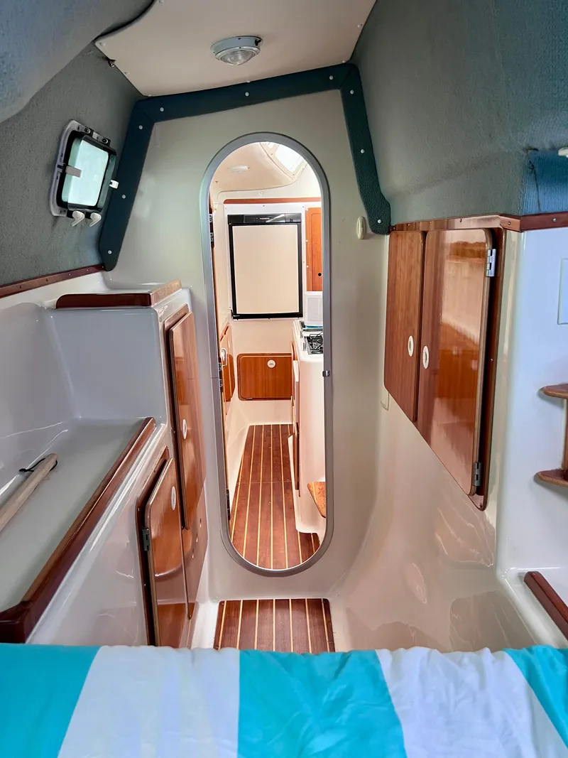 Slide: The Image of Interior of a 1994 PDQ 32 Classic boat, featuring wood cabinetry and striped flooring. - 41