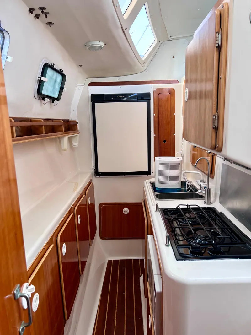 Slide: The Image of 1994 PDQ 32 Classic yacht interior with wooden cabinets and compact kitchen setup. - 42