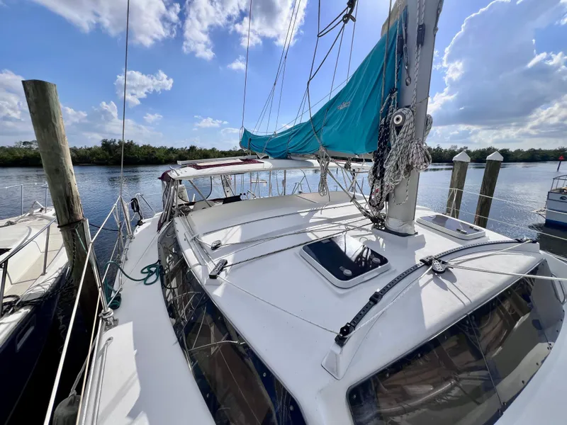 Slide: The Image of 1994 PDQ 32 Classic sailboat docked by a serene river under a blue sky. - 5