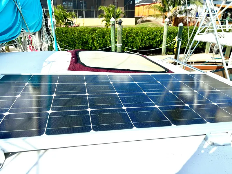 Slide: The Image of Solar panel on 1994 PDQ 32 Classic boat, docked with lush greenery in the background. - 9