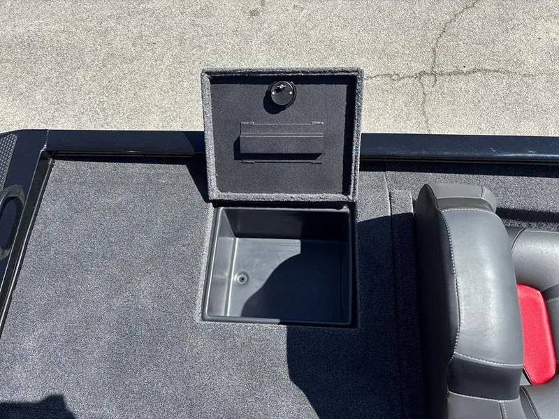Slide: The Image of 2025 Tracker Savage 215 boat storage compartment with open lid, gray interior, and adjacent seating. - 19