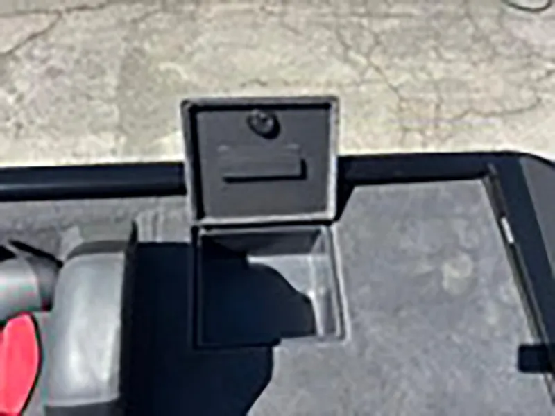 Slide: The Image of 2025 Tracker Savage 215 boat storage compartment with open lid on textured surface. - 20