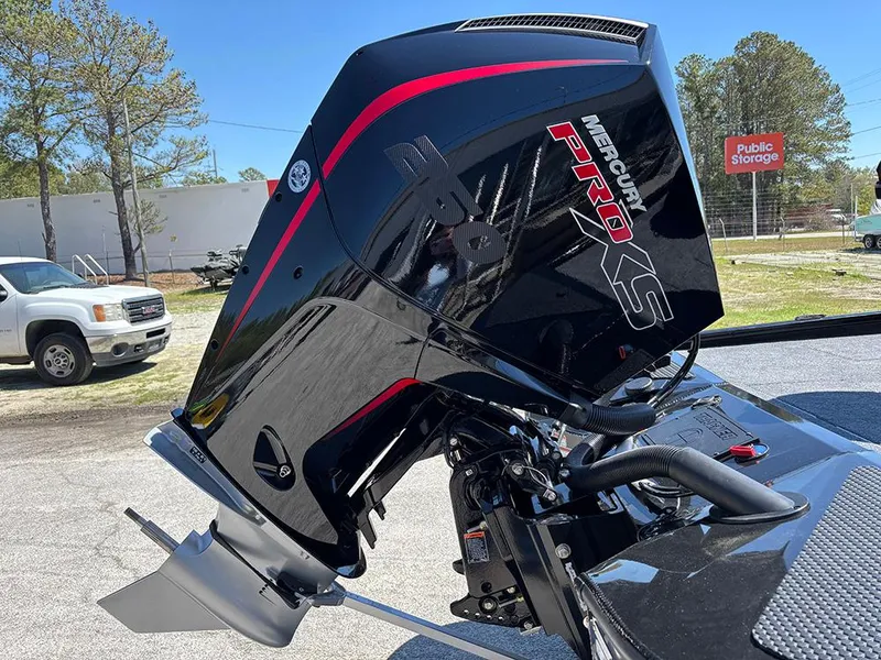 Slide: The Image of 2025 Tracker Savage 215 with Mercury Pro XS outboard motor in a parking lot. - 22