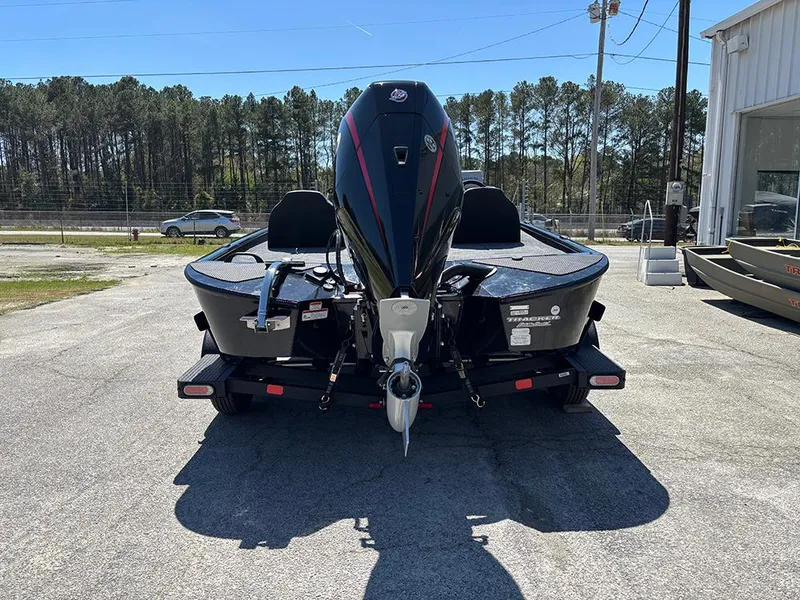 Slide: The Image of 2025 Tracker Savage 215 boat, rear view, parked outdoors on a sunny day. - 8
