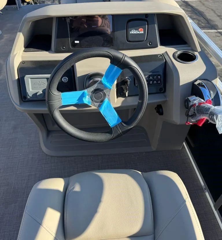 Slide: The Image of 2025 Sun Tracker SportFish 20 DLX boat steering console with protective tape on the wheel. - 7
