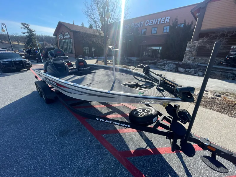 Slide: The Image of 2025 Tracker Savage 215 boat displayed outdoors at a boat center. - 11