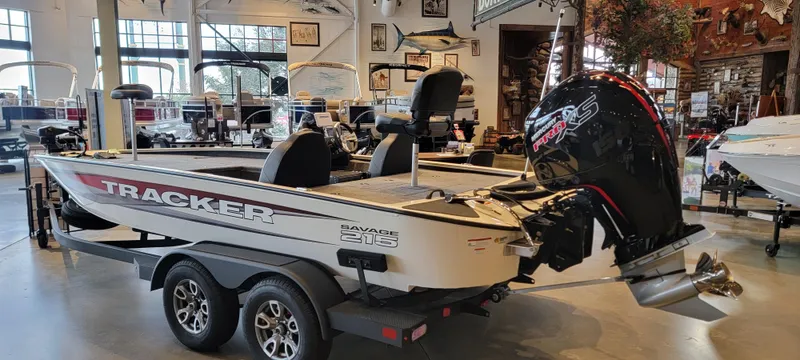Slide: The Image of 2025 Tracker Savage 215 boat dashboard with steering wheel and digital display. - 2