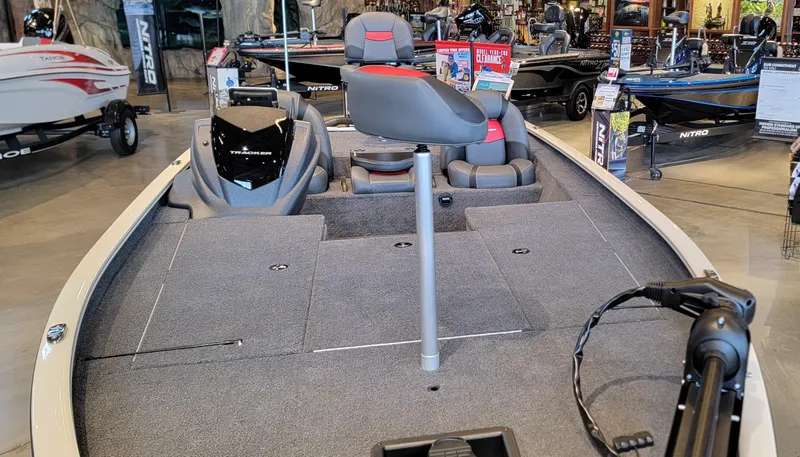 Slide: The Image of 2025 Tracker Savage 215 boat interior with gray and red seating, steering console visible. - 7