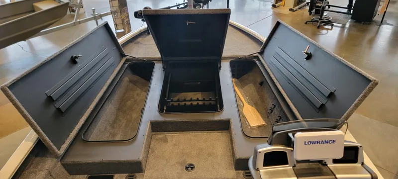 Slide: The Image of 2025 Tracker Savage 215 boat on trailer in showroom, featuring all-welded hull design. - 8