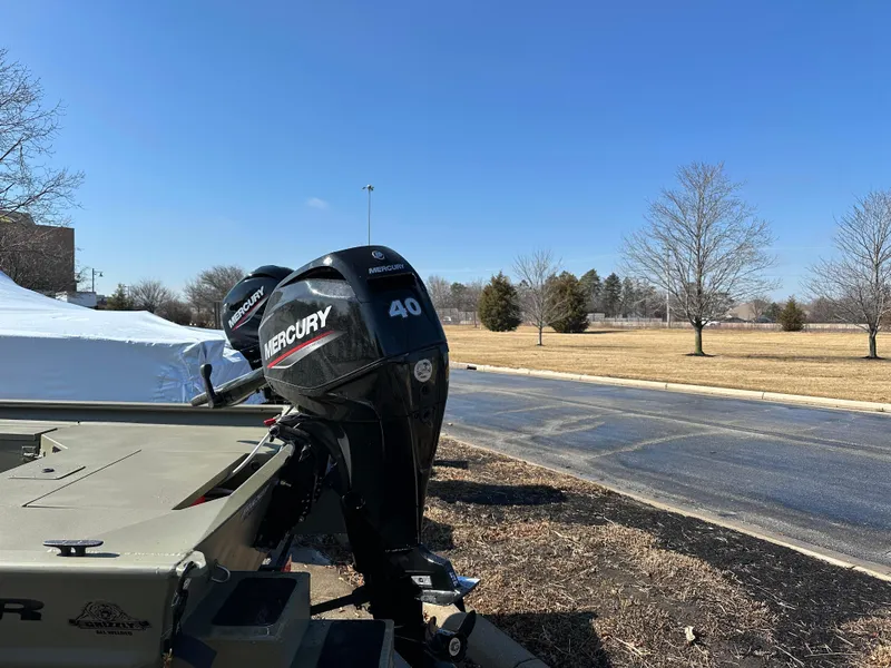 Slide: The Image of 2025 Tracker Grizzly 1654 T Sportsman with Mercury 40 outboard motor, parked outdoors. - 4
