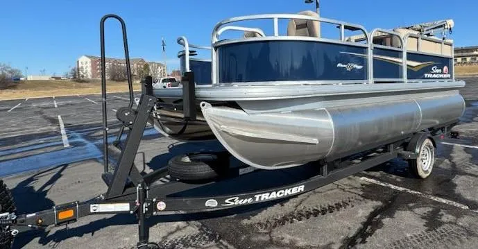 Slide: The Image of 2025 Sun Tracker Bass Buggy 16 XL Select pontoon boat on trailer in parking lot. - 4