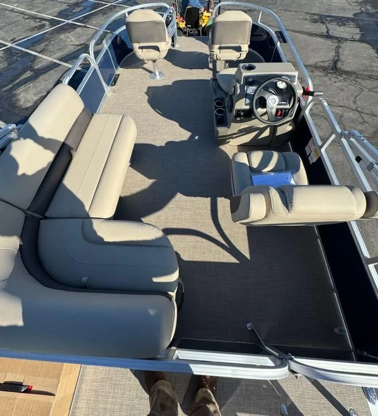 Slide: The Image of 2025 Sun Tracker Bass Buggy 16 XL Select pontoon boat interior with beige seating and steering console. - 9