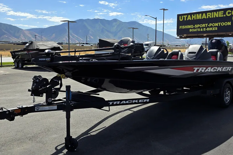 Slide: The Image of 2025 Tracker Savage 215 boat on trailer, mountains in background, Utah Marine sign visible. - 90