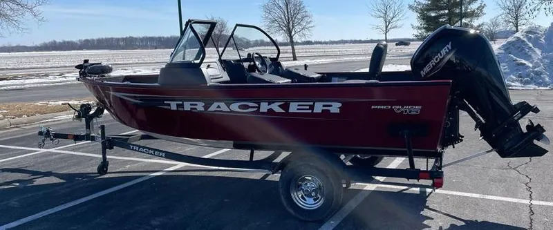 Slide: The Image of 2025 Tracker Pro Guide V-16 WT boat on trailer in parking lot. - 4