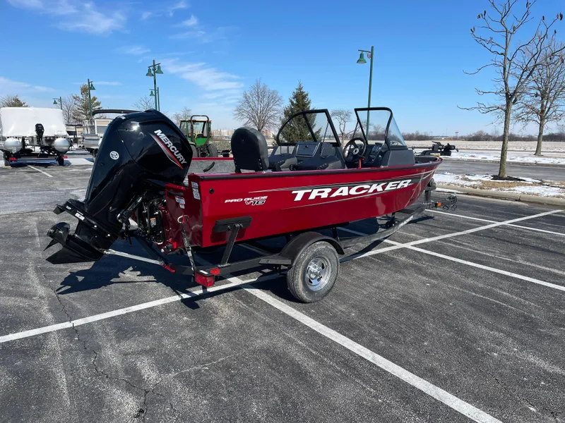 Slide: The Image of 2025 Tracker Pro Guide V-16 WT boat in parking lot, red exterior, outboard motor. - 6