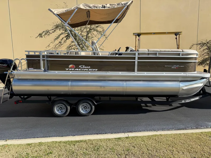 The Image of 2025 Sun Tracker SportFish 22 XP3 pontoon boat with canopy on a trailer. - 0