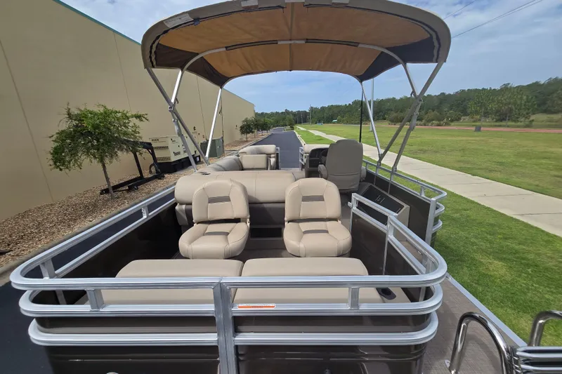 Slide: The Image of 2025 Sun Tracker SportFish 22 XP3 pontoon boat with beige seating and canopy on a sunny day. - 77