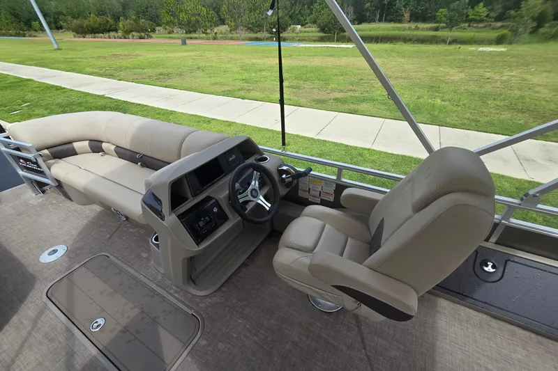 Slide: The Image of Interior of 2025 Sun Tracker SportFish 22 XP3 pontoon boat with beige seating and steering console. - 79