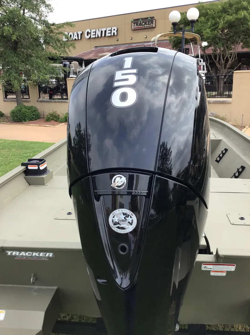 Slide: The Image of 2025 Tracker Grizzly 2072 CC boat with a 150 HP engine at a boat center. - 3