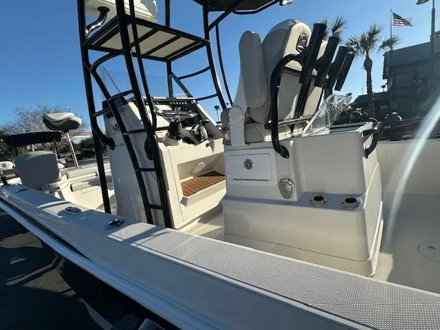 Slide: The Image of 2023 Ranger 2510 Bay boat interior with seating and control panel, under clear blue sky. - 2