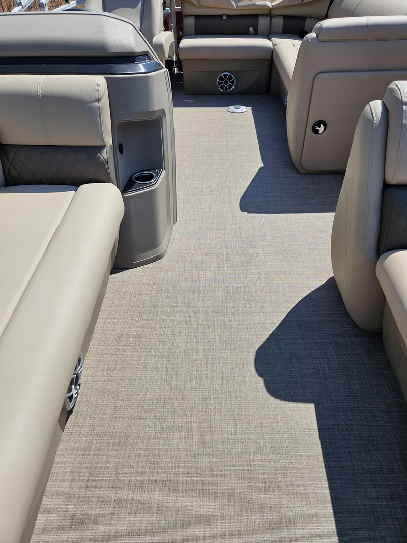Slide: The Image of 2025 Sun Tracker Party Barge 20 DLX interior with beige seating and flooring. - 3