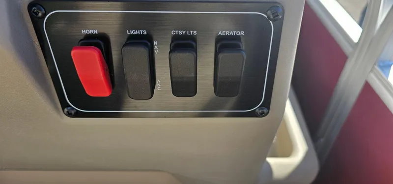 Slide: The Image of Control panel of 2025 Sun Tracker Bass Buggy 16 XL Select with switches for horn, lights, and aerator. - 11