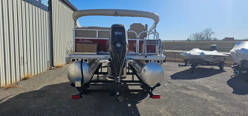 Slide: The Image of 2025 Sun Tracker Bass Buggy 16 XL Select pontoon boat with 50 HP engine, parked outdoors. - 3