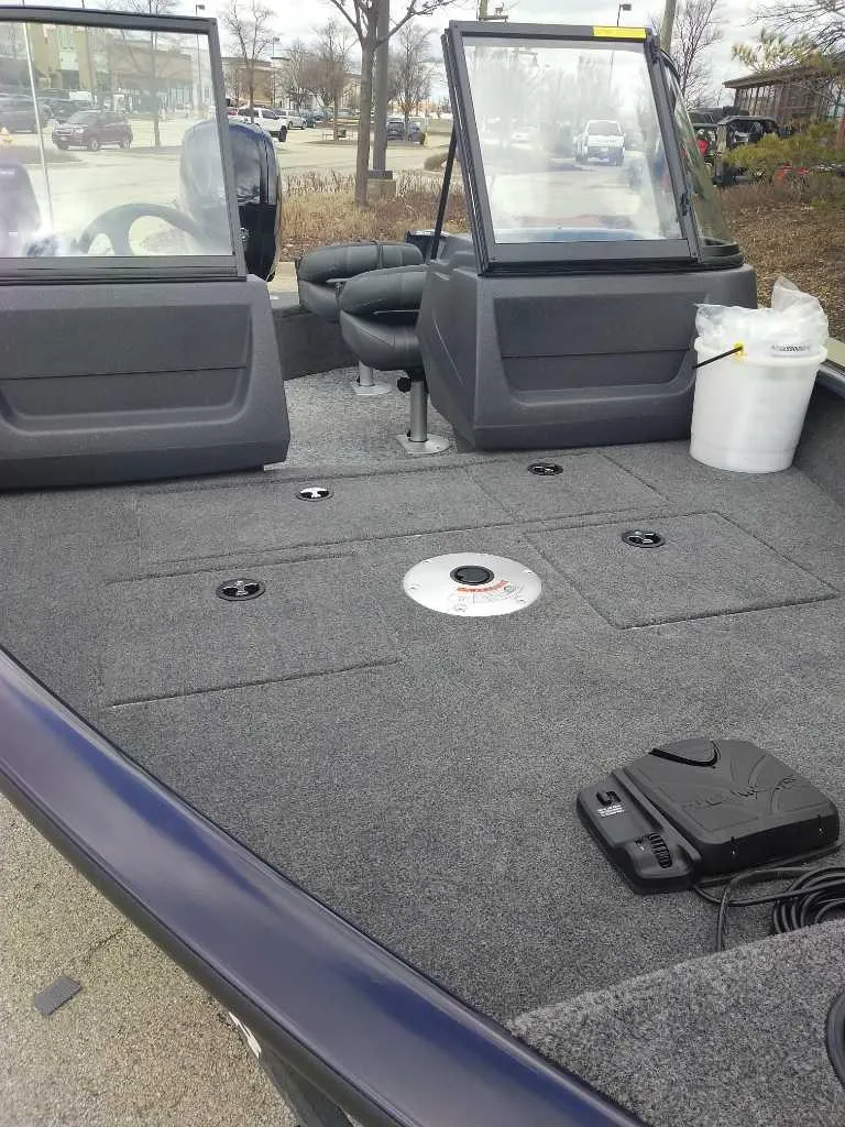 Slide: The Image of 2025 Tracker Pro Guide V-16 WT boat interior with seating and carpeted deck. - 2