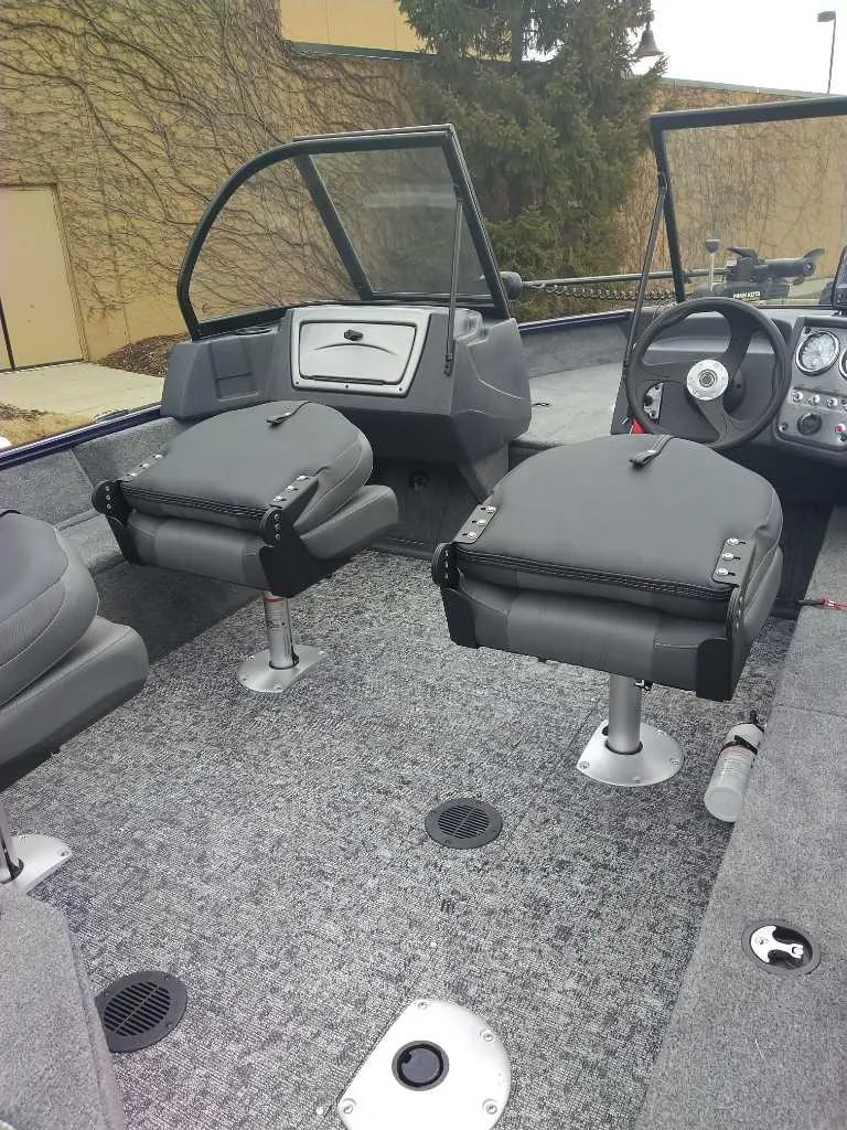 Slide: The Image of 2025 Tracker Pro Guide V-16 WT boat interior with gray seating and steering console. - 3
