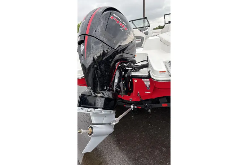 Slide: The Image of 2025 Tahoe 210 S boat with Mercury outboard motor, wet and parked on pavement. - 3