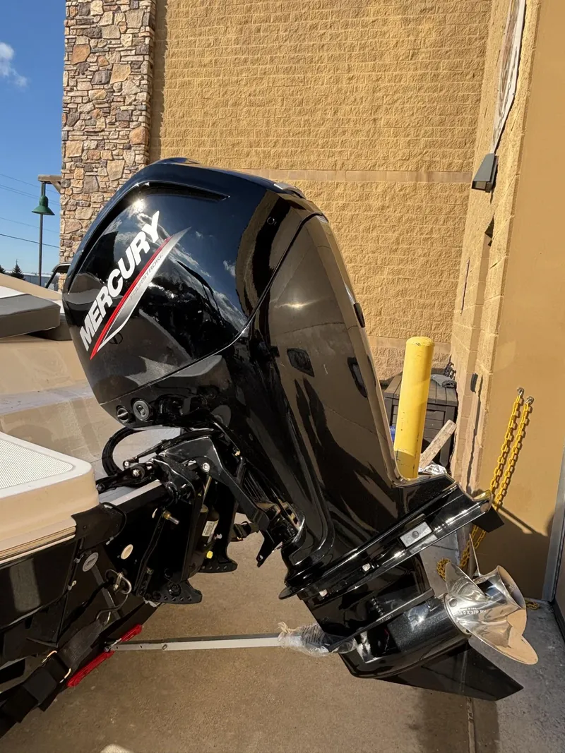 Slide: The Image of 2025 Tahoe T18 boat with Mercury outboard motor, parked outdoors. - 2