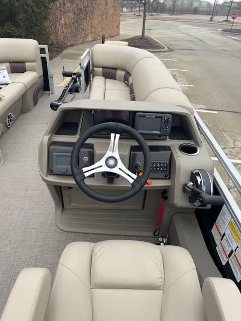 Slide: The Image of 2025 Sun Tracker SportFish 22 DLX boat interior with steering wheel and control panel. - 2