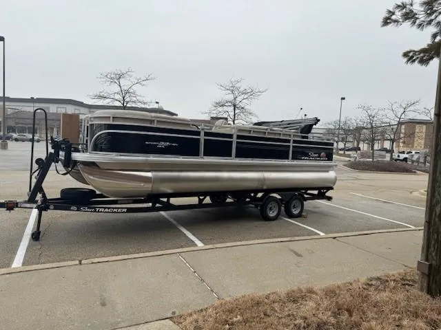 Slide: The Image of 2025 Sun Tracker SportFish 22 DLX pontoon boat on trailer in parking lot. - 7