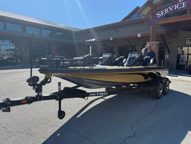 Slide: The Image of 2025 Nitro Z19 Pro boat on trailer outside service center, sunny day. - 2