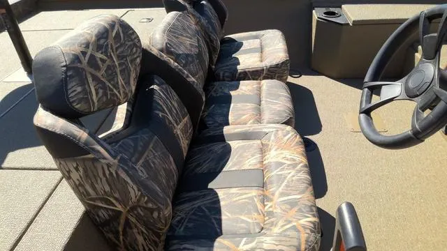 Slide: The Image of 2025 G3 Sportsman 1710 boat interior with camo-patterned seats and steering wheel. - 6