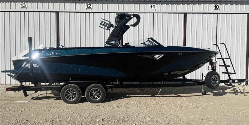 Slide: The Image of 2024 Tigé Z5 boat on trailer, parked outdoors, side view. - 0