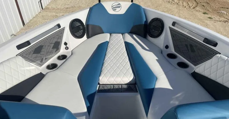 Slide: The Image of 2024 Tigé Z5 boat interior with blue and white seating, cup holders, and speakers. - 5