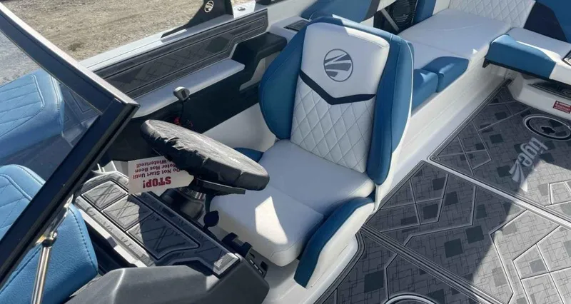 Slide: The Image of 2024 Tigé Z5 boat interior with blue and white seating, modern dashboard, and stylish flooring. - 6