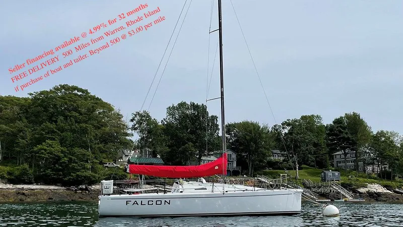 Slide: The Image of Sailboat Columbia Carbon 32, 2012 model, anchored near shoreline with trees and houses. - 25