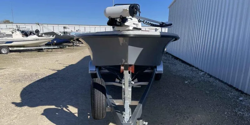 Slide: The Image of 2024 Blazer Bay 2400 boat on trailer, parked outdoors near metal building. - 16