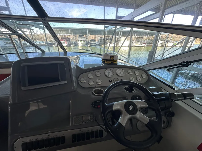 Slide: The Image of 2005 Cruisers Yachts 340 Express helm with steering wheel and dashboard controls. - 3