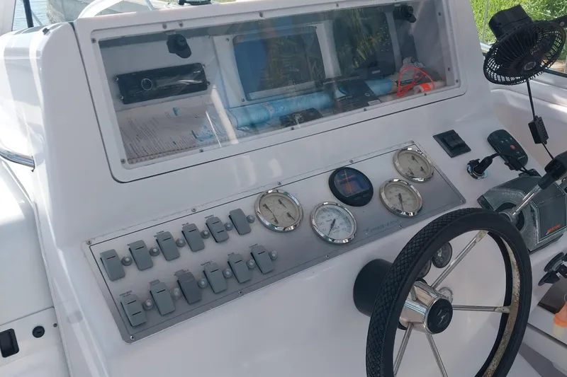 Slide: The Image of Control panel of a 2000 Pro-Line 2810 Walkaround boat with gauges and steering wheel. - 10