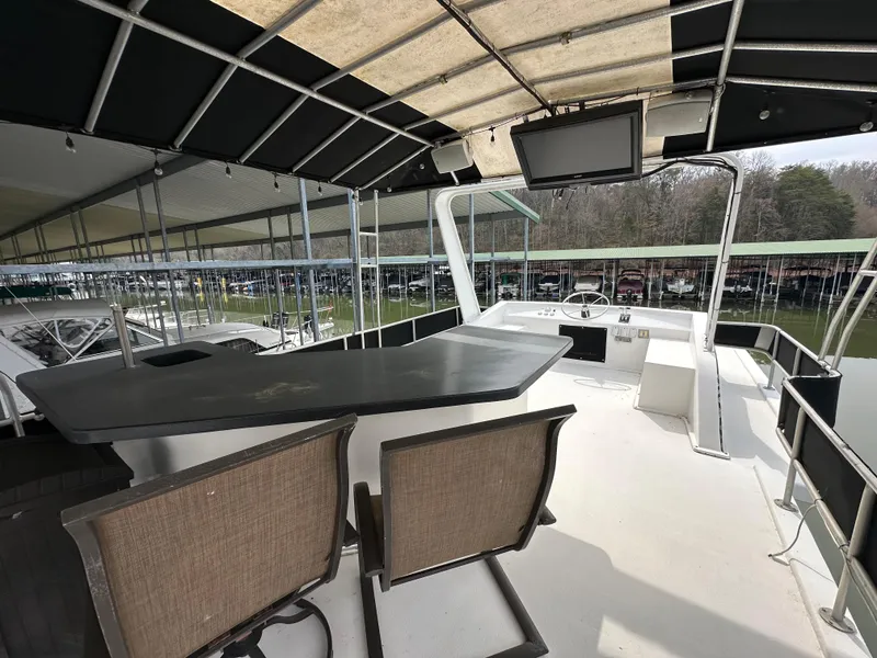 Slide: The Image of 1991 Sumerset 14x60 houseboat deck with seating, table, and covered helm area. - 11